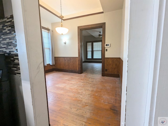 unfurnished dining area with wood walls and light wood-type flooring