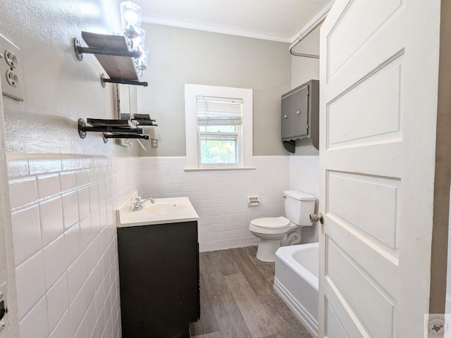 bathroom with tile walls, hardwood / wood-style flooring, ornamental molding, toilet, and vanity