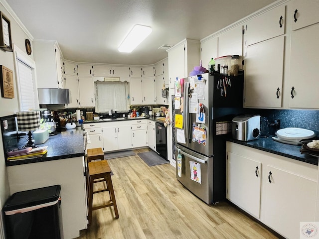 kitchen featuring sink, white cabinets, black dishwasher, and tasteful backsplash