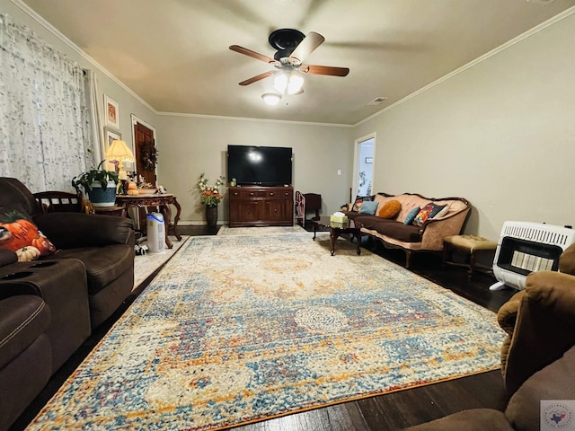 living room with heating unit, ceiling fan, crown molding, and wood-type flooring