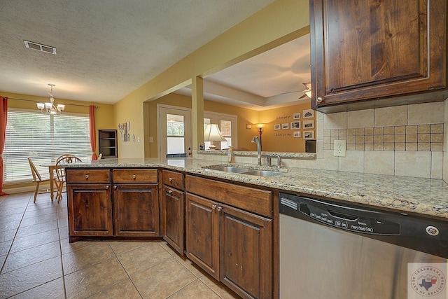 kitchen featuring a textured ceiling, sink, kitchen peninsula, light stone counters, and stainless steel dishwasher