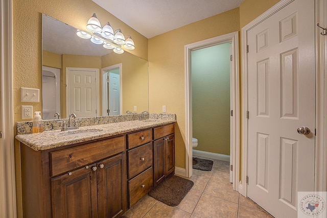 bathroom with toilet, tile patterned flooring, and vanity