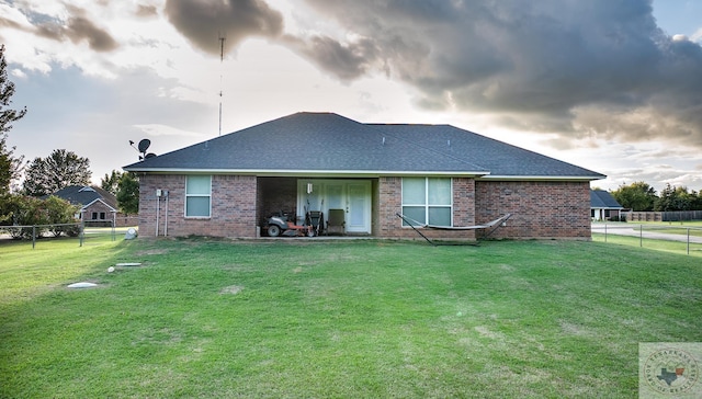 rear view of property featuring a yard