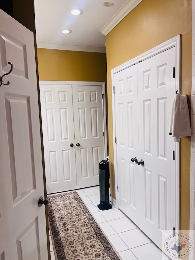 foyer with light tile patterned flooring and ornamental molding