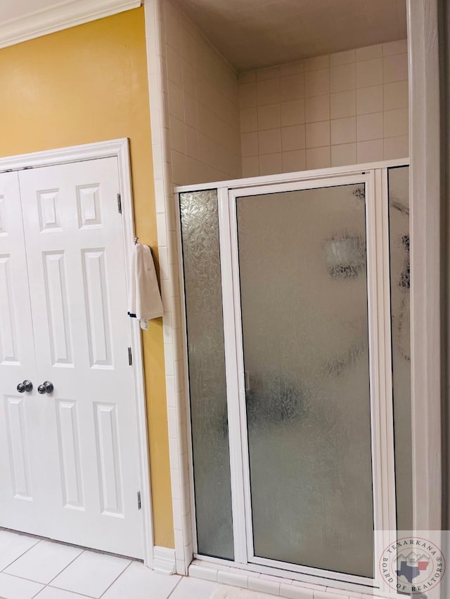 bathroom with an enclosed shower and tile patterned flooring