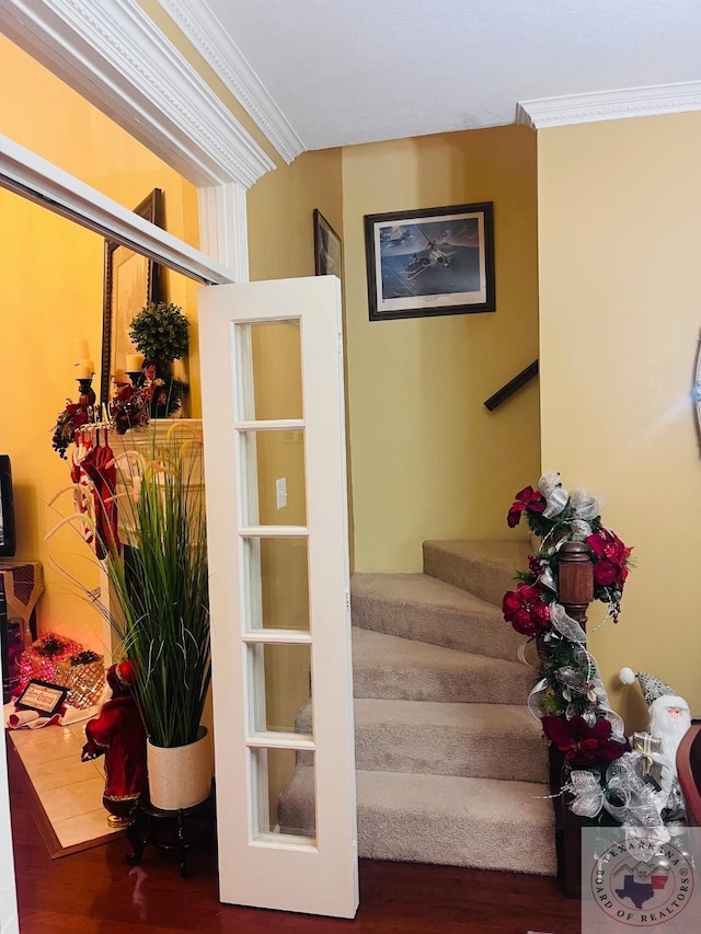 stairway featuring crown molding and hardwood / wood-style floors