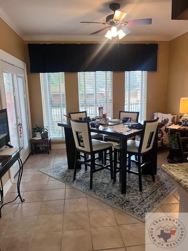 tiled dining space with crown molding, plenty of natural light, and ceiling fan