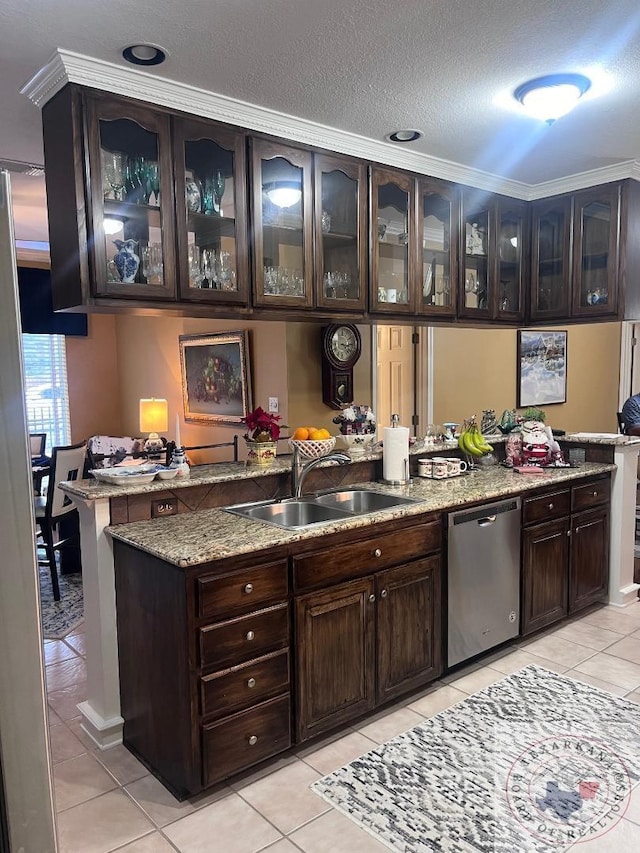 bar featuring sink, dark brown cabinets, stainless steel dishwasher, and light tile patterned floors