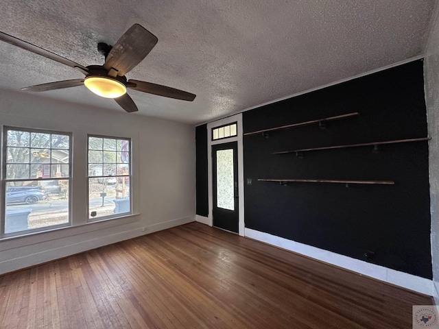 spare room with hardwood / wood-style floors, a textured ceiling, and ceiling fan