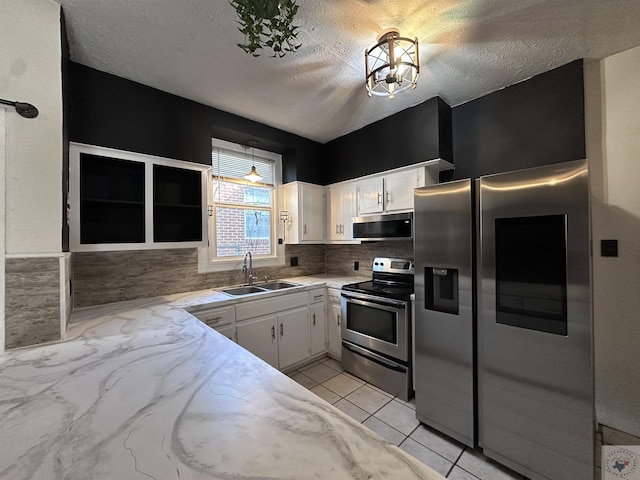 kitchen with sink, white cabinets, tasteful backsplash, and stainless steel appliances