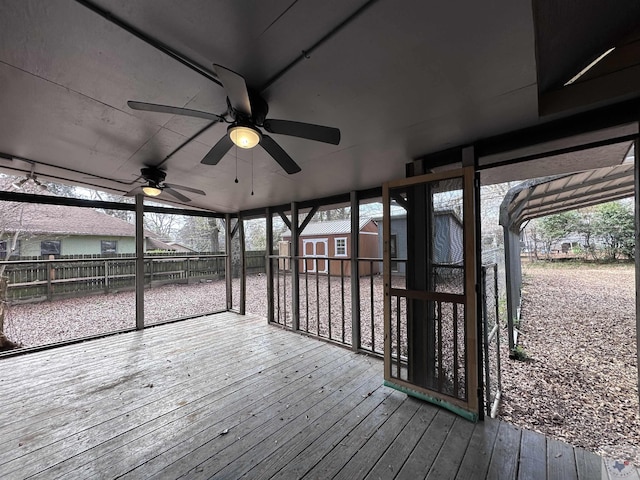 wooden deck featuring ceiling fan and a shed