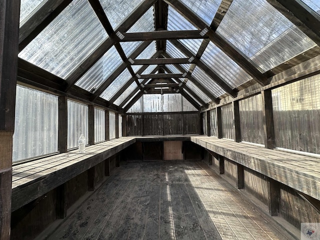 miscellaneous room with hardwood / wood-style flooring, wooden walls, and lofted ceiling