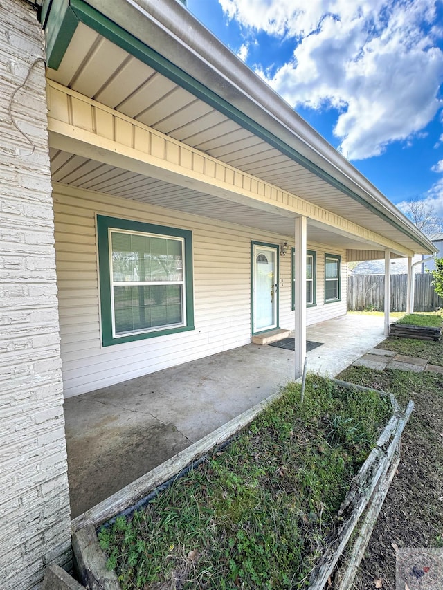 view of exterior entry with a patio area