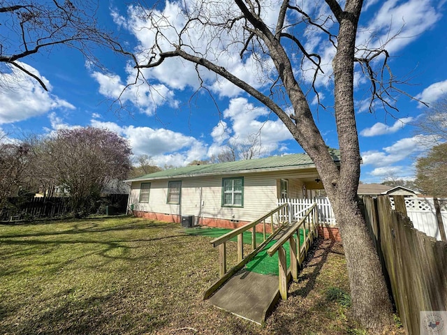 back of house featuring a lawn and central AC