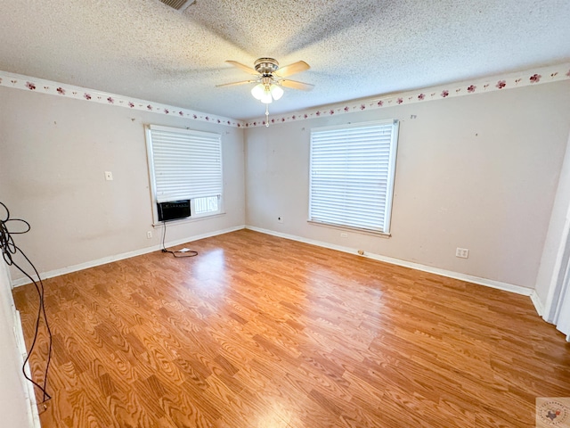 spare room with a textured ceiling, light hardwood / wood-style flooring, and ceiling fan