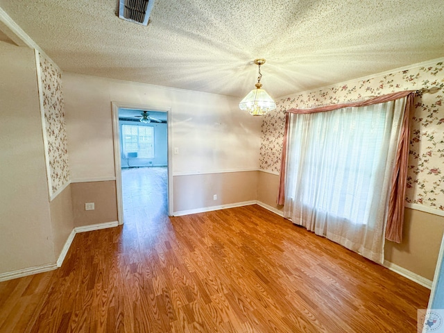 unfurnished dining area featuring hardwood / wood-style flooring and a textured ceiling