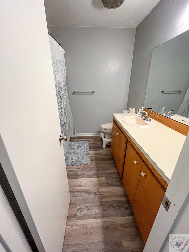 bathroom featuring wood-type flooring, vanity, and toilet