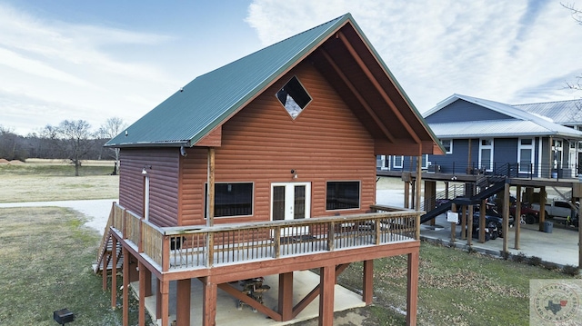 back of property featuring a wooden deck and a lawn