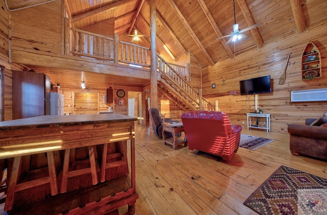 living room with hardwood / wood-style floors, wood ceiling, wooden walls, high vaulted ceiling, and beam ceiling