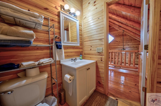 bathroom featuring toilet, vanity, wood ceiling, and wooden walls