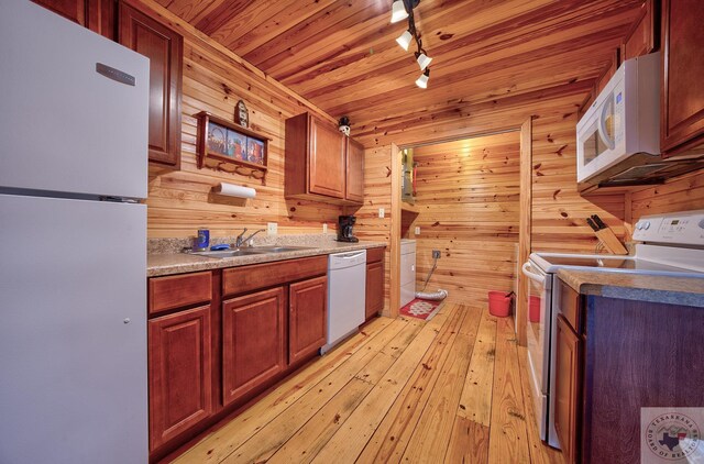 kitchen featuring sink, wood ceiling, white appliances, rail lighting, and wooden walls