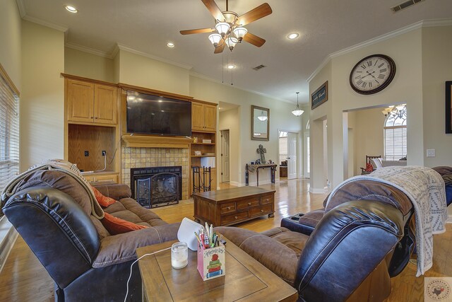 living area featuring light wood finished floors, visible vents, a fireplace, and ceiling fan