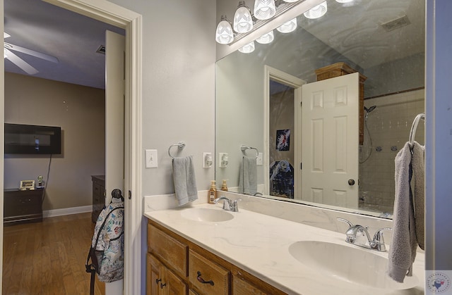 full bathroom featuring a sink, wood finished floors, double vanity, and ceiling fan