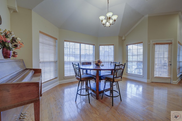 dining space with a chandelier, high vaulted ceiling, light wood-type flooring, and baseboards