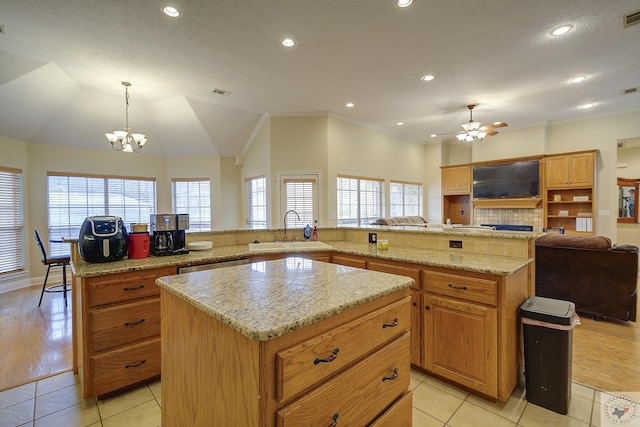 kitchen featuring a spacious island, visible vents, light tile patterned floors, and a sink