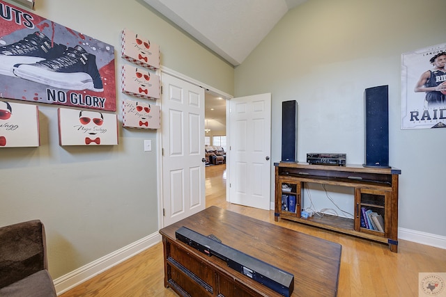 office space featuring lofted ceiling, wood finished floors, and baseboards