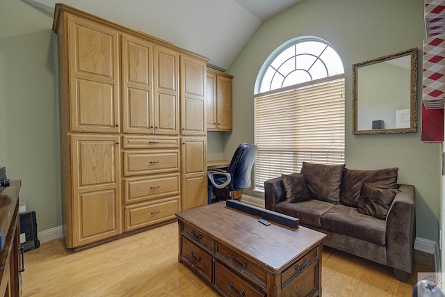 living area with light wood-type flooring, lofted ceiling, and baseboards