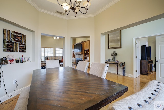 dining room with a chandelier, visible vents, and ornamental molding