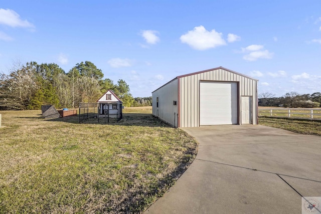 view of outbuilding featuring an outbuilding, concrete driveway, and fence