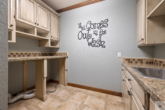 kitchen featuring open shelves, baseboards, ornamental molding, a textured ceiling, and a sink