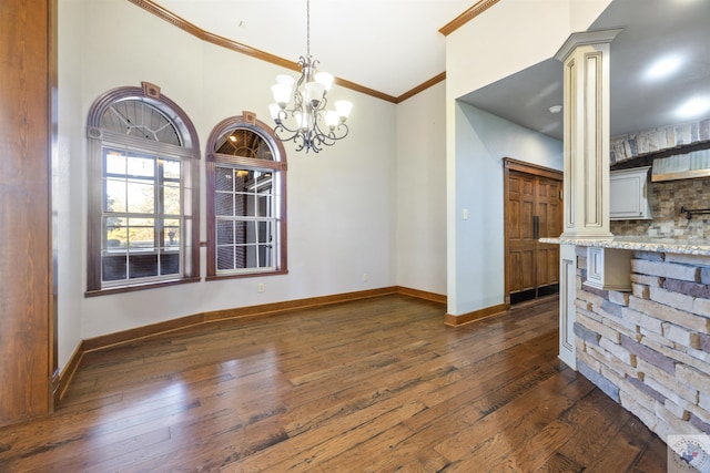 unfurnished dining area featuring baseboards, crown molding, ornate columns, and dark wood-style flooring