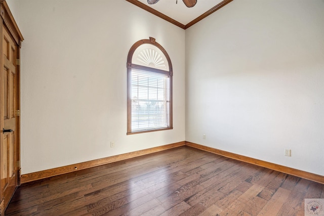 empty room with dark wood finished floors, a ceiling fan, baseboards, and ornamental molding