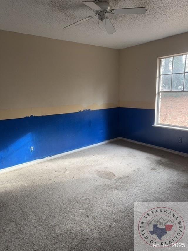 unfurnished room featuring a textured ceiling, ceiling fan, and carpet floors