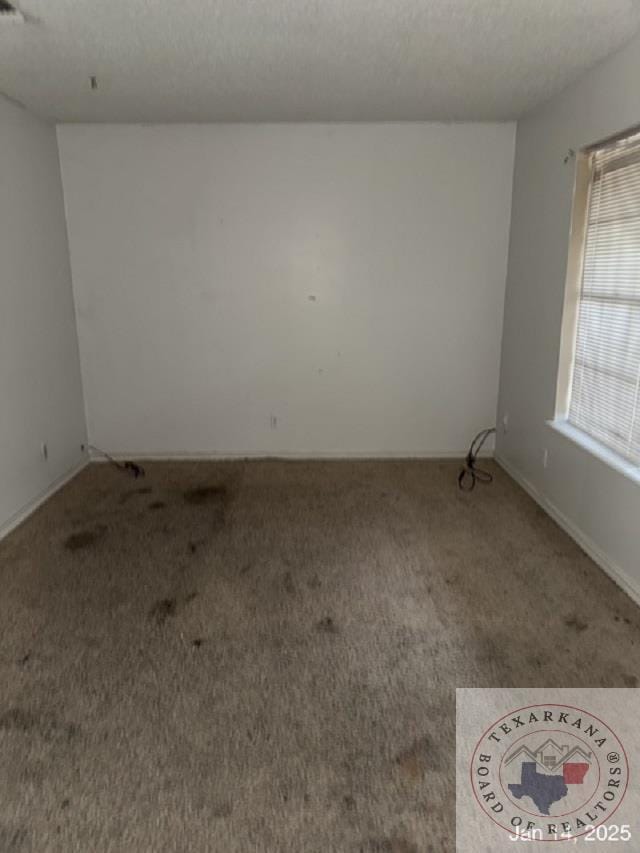 carpeted spare room with a textured ceiling