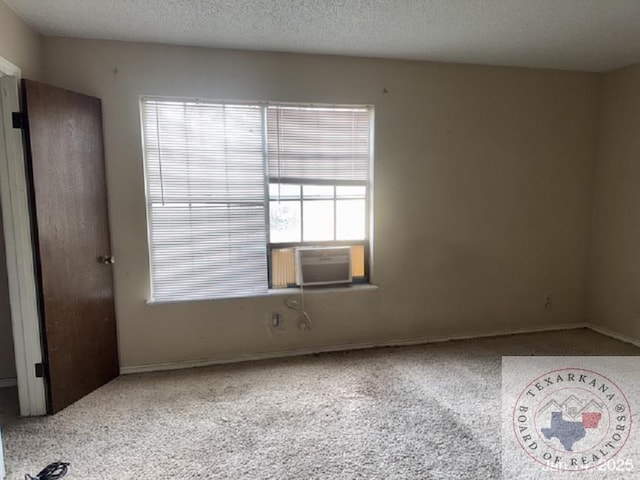 carpeted spare room with a textured ceiling and cooling unit