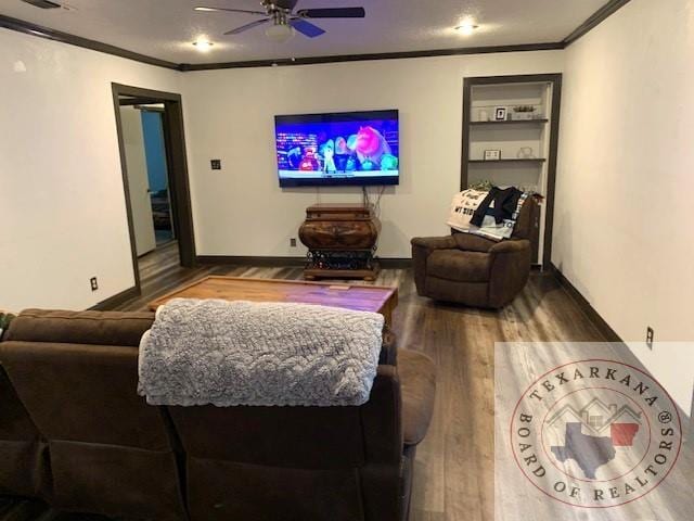 living room featuring built in features, ceiling fan, hardwood / wood-style floors, and crown molding