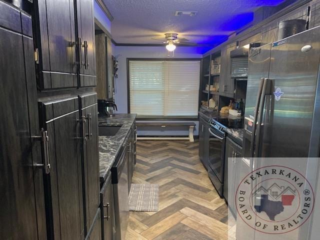 kitchen featuring ceiling fan, appliances with stainless steel finishes, a textured ceiling, parquet flooring, and dark stone counters