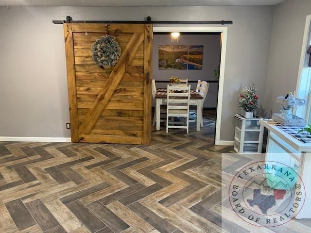 interior space featuring a barn door and dark parquet flooring