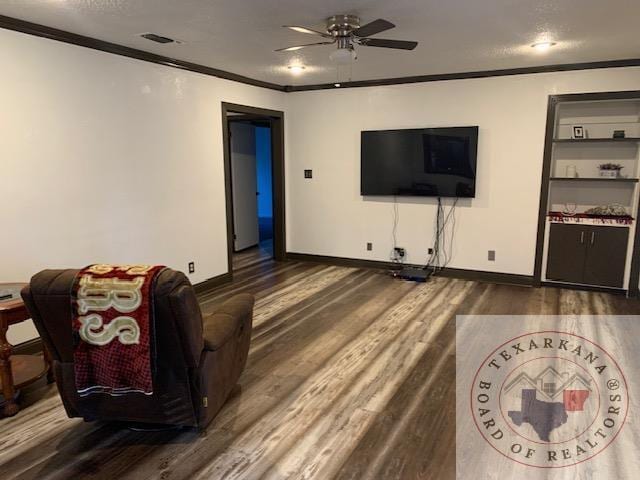 living room featuring ceiling fan, ornamental molding, dark hardwood / wood-style floors, and a textured ceiling