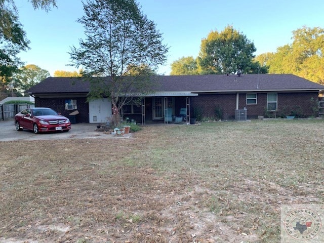 single story home featuring cooling unit and a front lawn