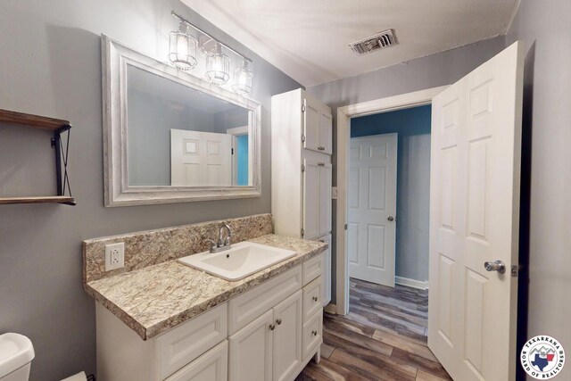 2101 N Fm 2148, Texarkana, TX 75501 - half bathroom with vanity, wood finished floors, and toilet