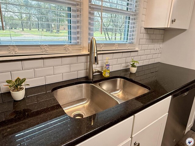 2101 N Fm 2148, Texarkana, TX 75501 - kitchen view of a sink, stainless steel dishwasher, white cabinetry, decorative backsplash, and dark stone countertops