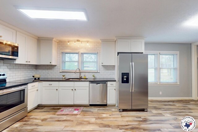 2101 N Fm 2148, Texarkana, TX 75501 - kitchen with appliances with stainless steel finishes, a sink, light wood-style floors, and backsplash