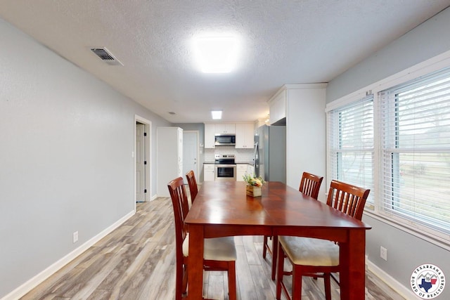 2101 N Fm 2148, Texarkana, TX 75501 - dining area with light wood finished floors, a textured ceiling, and baseboards