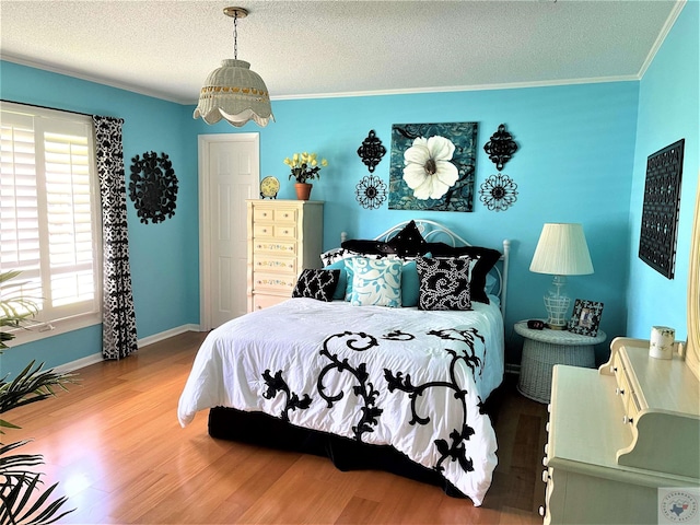 501 Park St, Atlanta, TX 75551 - bedroom with a textured ceiling, ornamental molding, wood finished floors, and baseboards