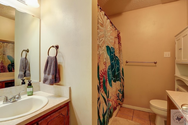 bathroom featuring tile patterned flooring, vanity, toilet, and a textured ceiling